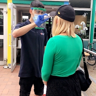 Einlasskontrolleur beim Fieber messen für Pohlposition