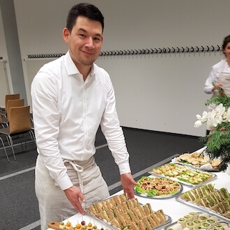 Servicekraft beim Vorbereiten eines offenen Buffets