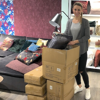 Lagerhelferin verpackt Ware in Kartons